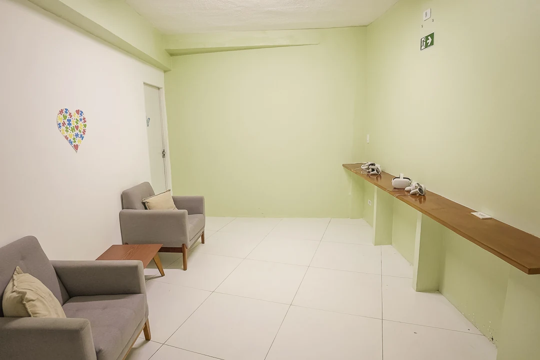 Sala de convivência da Laços Vivos, em Olinda, com poltronas e paredes em verde claro
