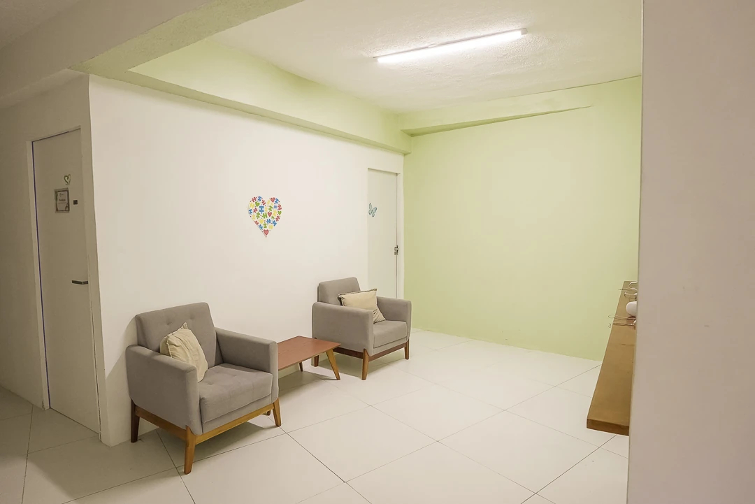 Sala de convivência da Laços Vivos, em Olinda, com poltronas e paredes em verde claro